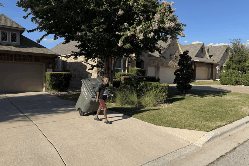 Snack Ambassadors moving a trash can out to the curb and back